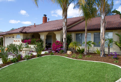Spanish style home with artificial grass front lawn